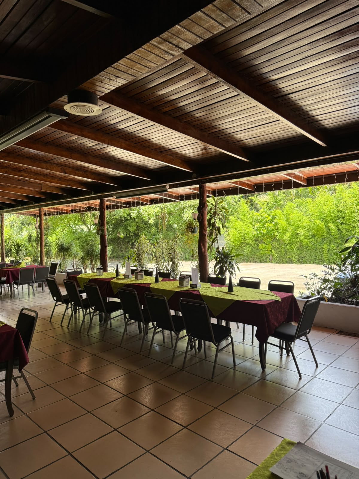 Mesas de Los Adobes bajo techo de madera rodeadas de vegetación